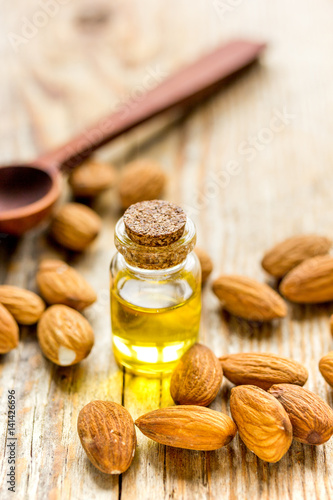 spa with almond oil in organic cosmetic set on wooden background