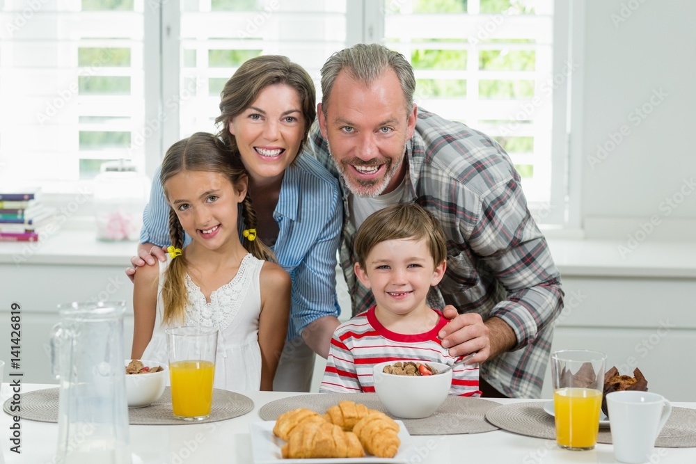 Smiling family having breakfast in the kitchen
