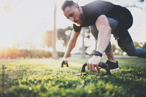 Healthy lifestyle concept.Young athlete exercising push up outside in sunny park. Fit shirtless male fitness model in crossfit exercise outdoors.Sport fitness man doing push-ups.