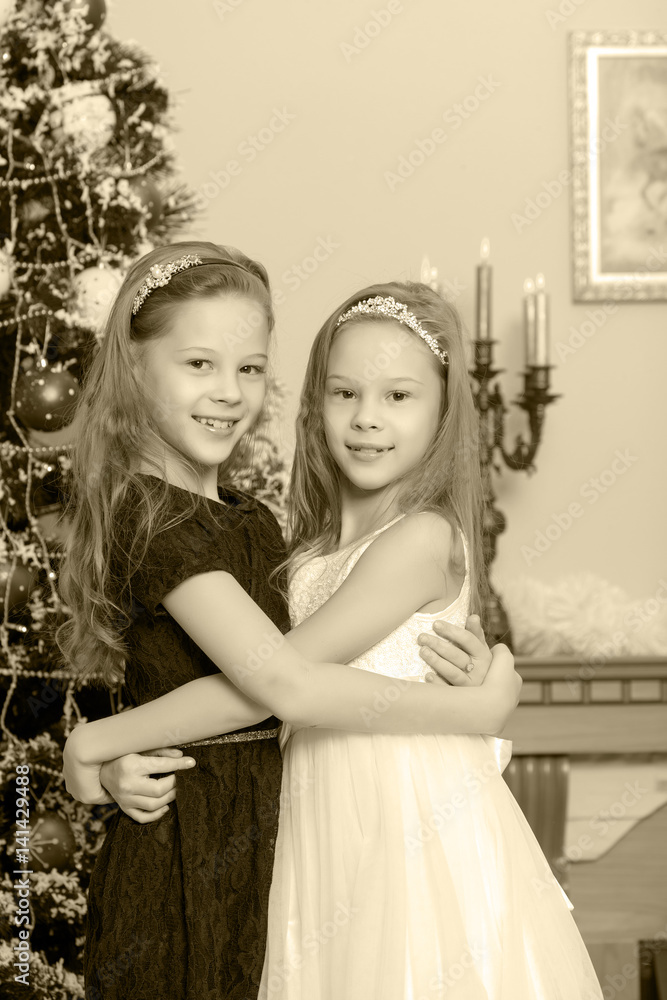 Girls twins with gifts e Christmas tree.