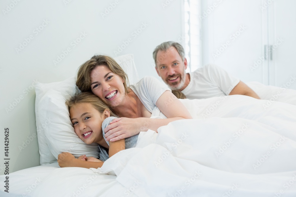 Happy family lying on bed in bedroom at home Happy family lying on bed in bedroom at home