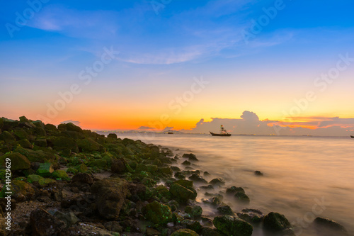 Rock on the beach and warm sky background with long exposure