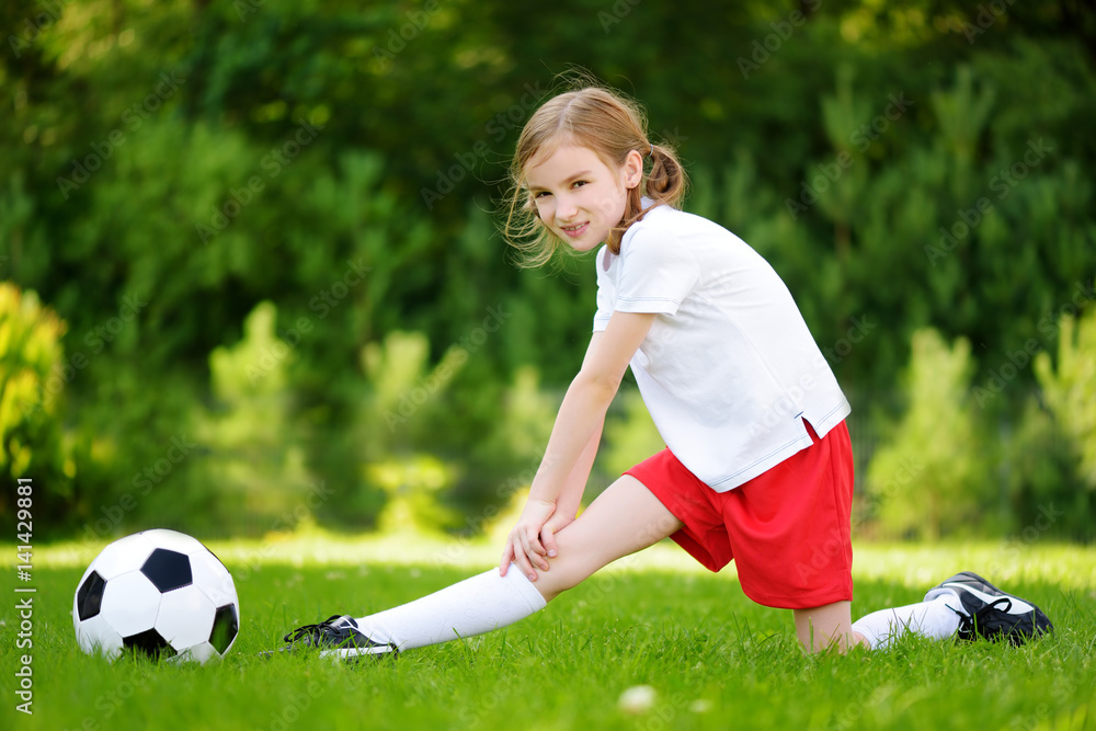 Cute little soccer player having fun playing a soccer game on summer day Cute little soccer player having fun playing a soccer game on summer day