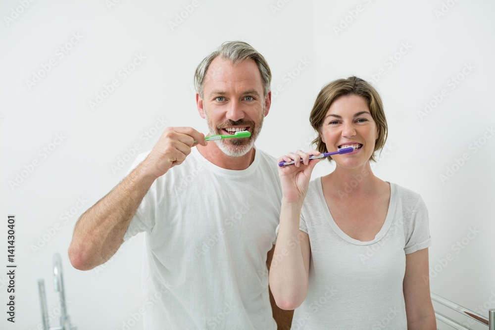 Couple brushing their teeth with toothbrush at home Couple brushing their teeth with toothbrush at home