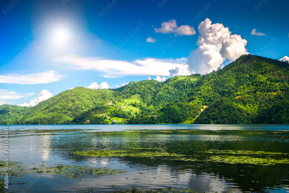 Beautiful green hills landscape with reflection on water at Phewa lake, Pokhara. Relax after trekking in Himalaya mountains, Nepal. Nature landscape. Travel background. Holidays and recreation