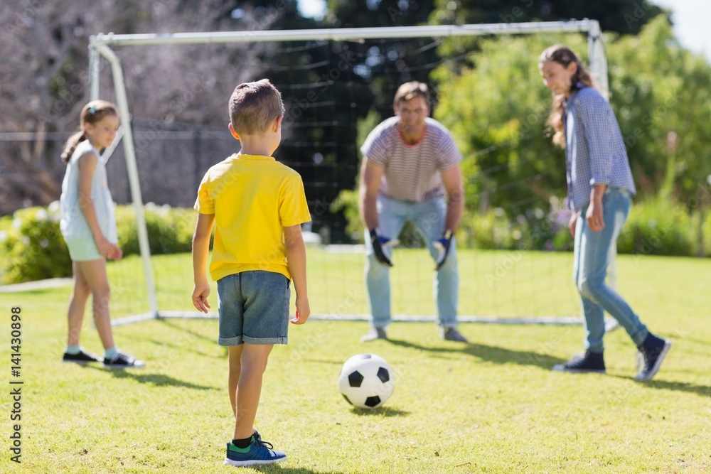 Happy family playing football in the park