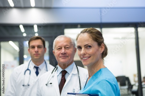 Smiling doctors and surgeon standing together in hospital