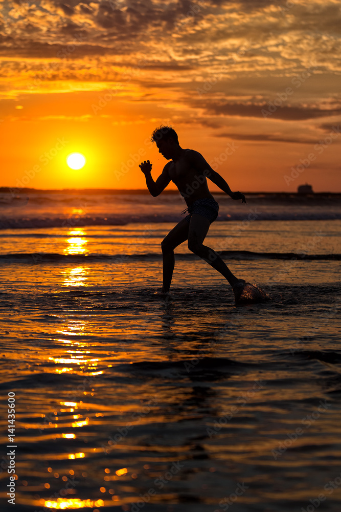 Silhouette of young male capoeira dancer, yoga and martial art specialist at beach in Mexico during spectacular sunset Silhouette of young male capoeira dancer, yoga and martial art specialist at beach in Mexico during spectacular sunset