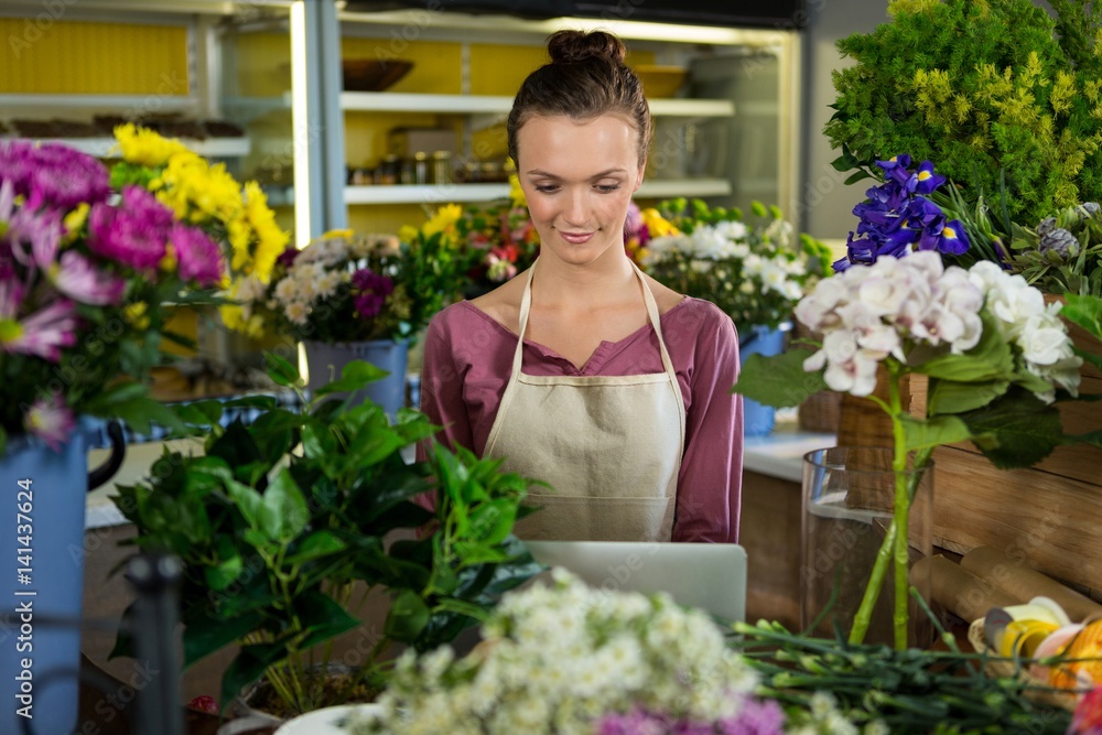 Florist using laptop in flower shop