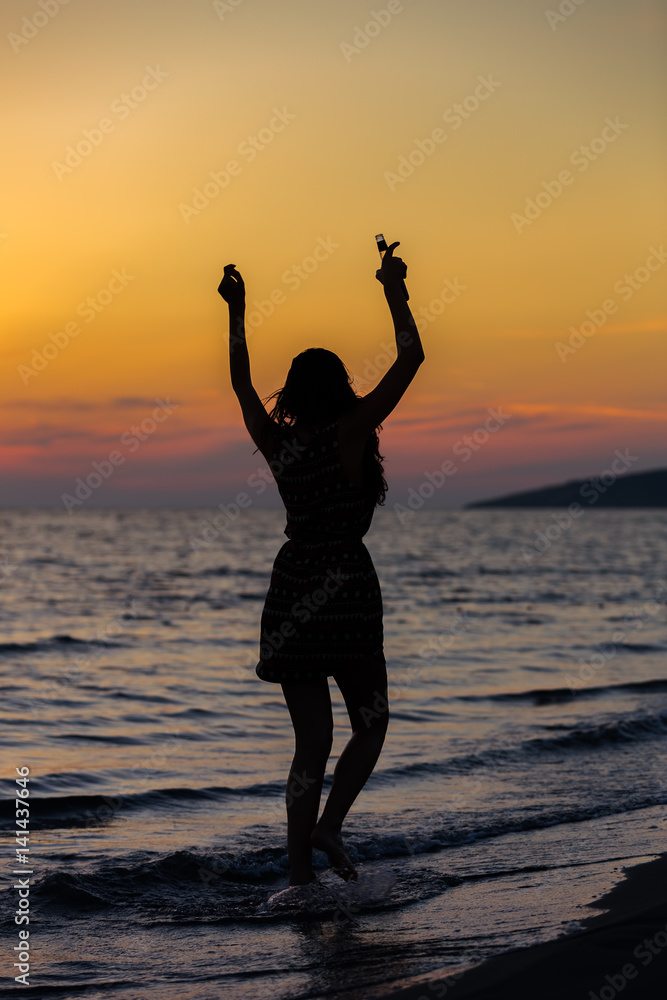 Silhouette of a sensual woman at sunrise on the beach, sexy body, perfect figure, enjoying life
