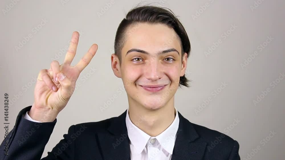 Sign of Victory By Businessman on grey Background Sign of Victory By Businessman on grey Background