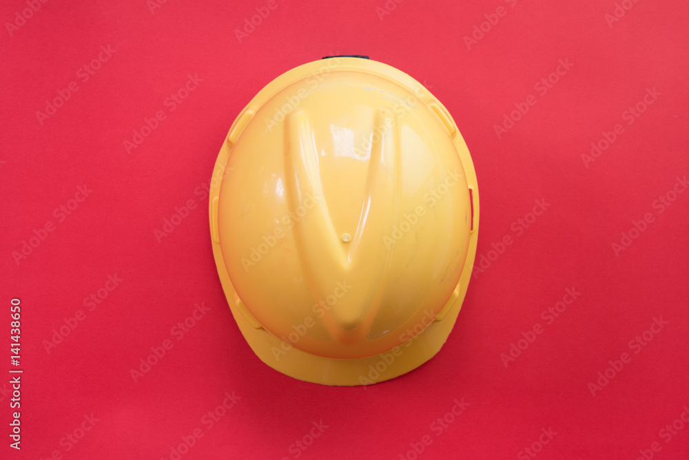 Flat lay of safety hat on red background.