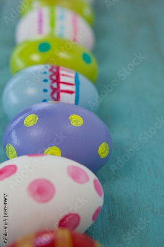 Various Easter eggs arranged on wooden surface