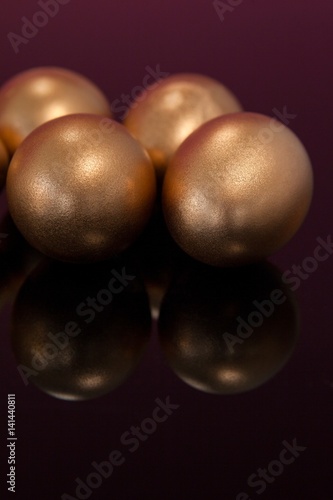 Golden Easter eggs on colored background