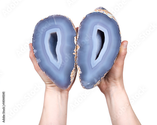 Young woman holding partially polished blue lace agate geode with crystaline druzy center isolated on white background photo