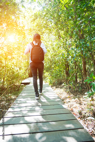 woman trekking in forest and sun light
