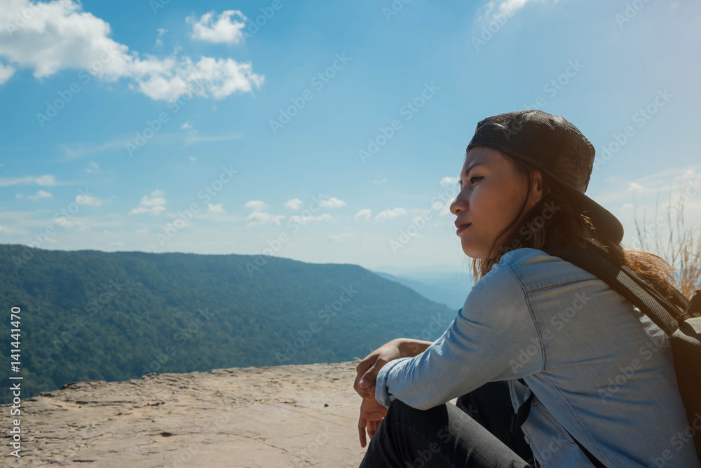 woman hiking sit down enjoy the beautiful view at mountain for sun light