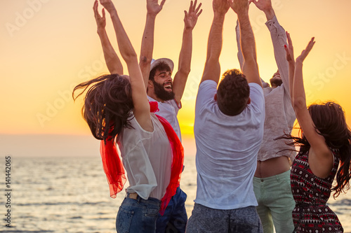 Young People Dancing On Beach at Sunset