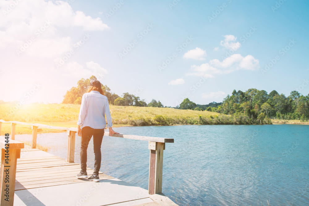 Happy woman with walking on Bridge and lagoon at sunset