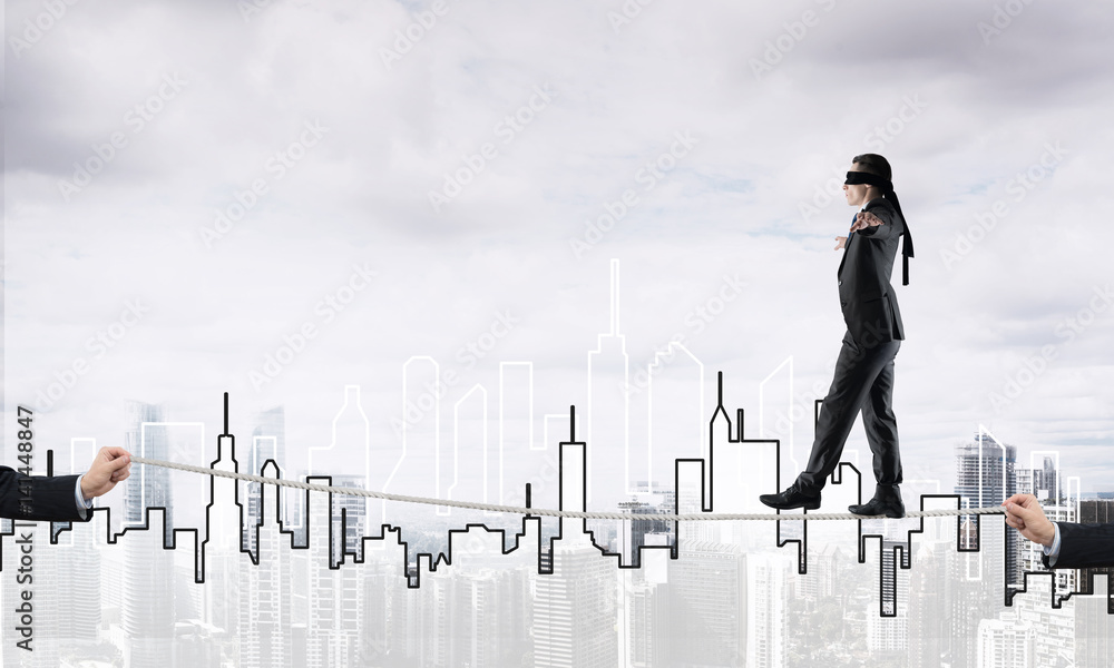 Business concept of risk support and assistance with man balancing on rope Business concept of risk support and assistance with man balancing on rope