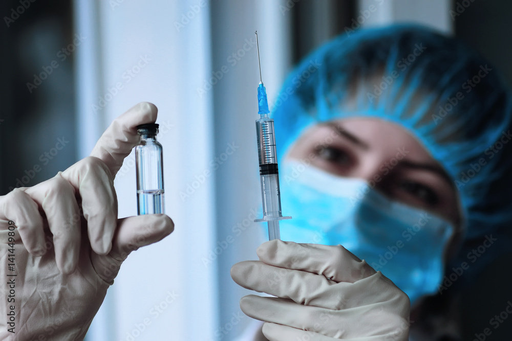 health worker dials the vaccine into a syringe health worker dials the vaccine into a syringe