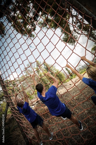 People climbing a net during obstacle course