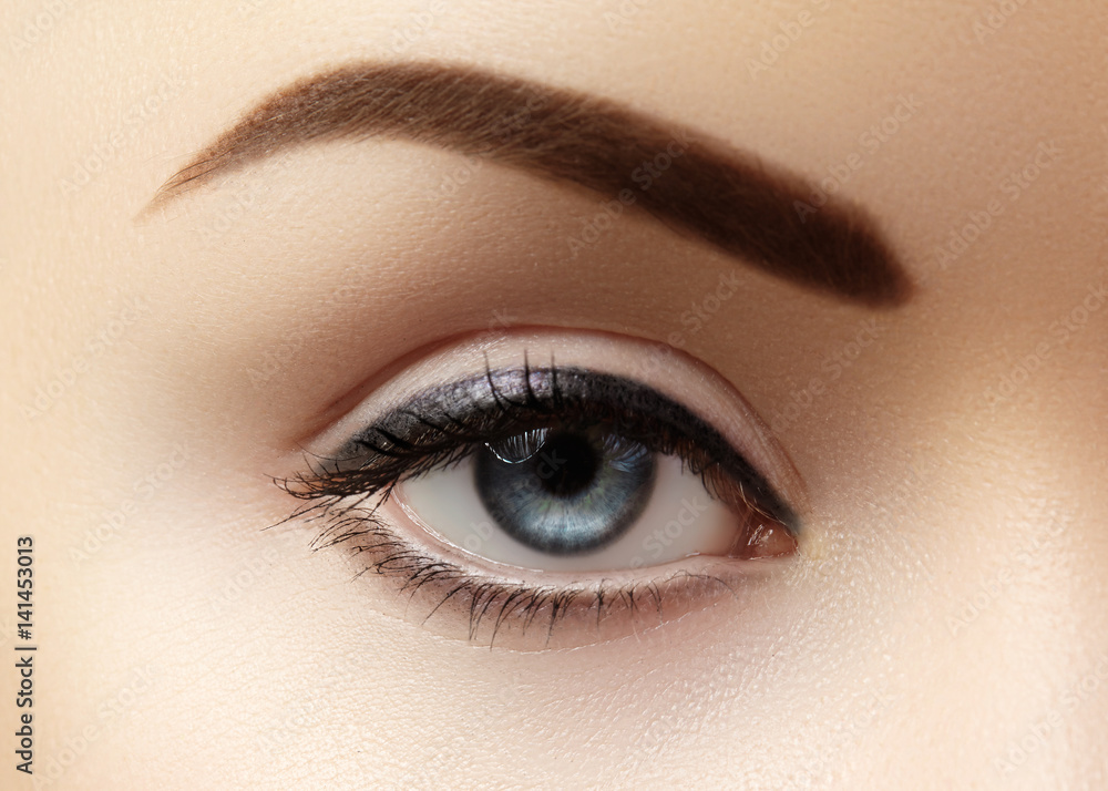 Obraz premium Close-up macro of beautiful female eye with perfect shape eyebrows. Clean skin, fashion naturel make-up. Good vision