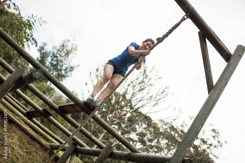 Fit woman holding the rope during obstacle course