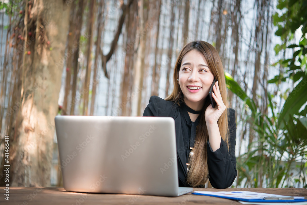 Young business woman talking on the phone while sitting at her working place. Young business woman talking on the phone while sitting at her working place.