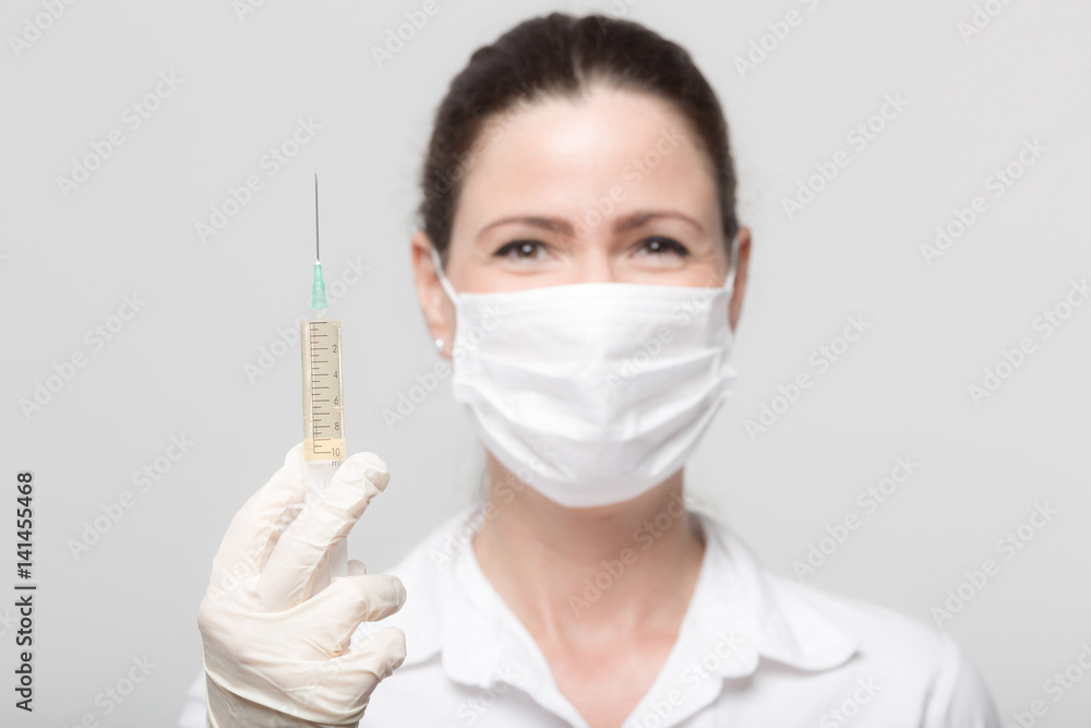Ärztin mit Spritze und Mundschutz