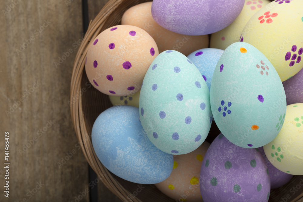 Fototapeta premium Close Up of Painted Eggs in Wicker Bowl Copy Space