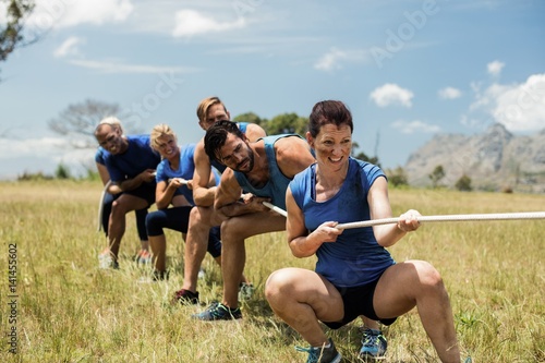Konstfotografi People playing tug of war during obstacle training course