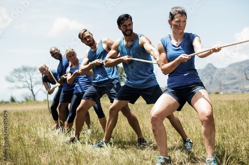 People playing tug of war during obstacle training course photo