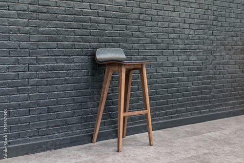 Bar chair wood and leather seat, brick wall background, minimalism interior concept