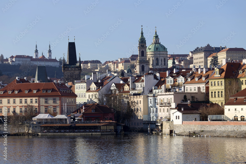 Fototapeta premium View on the autumn Prague St. Nicholas' Cathedral above River Vltava, Czech Republic