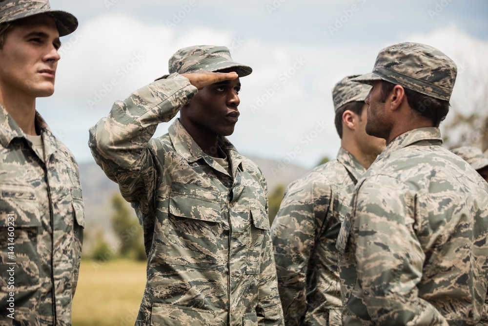 Mixed race military trainer giving training to military soldier