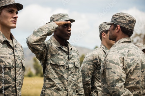 Mixed race military trainer giving training to military soldier