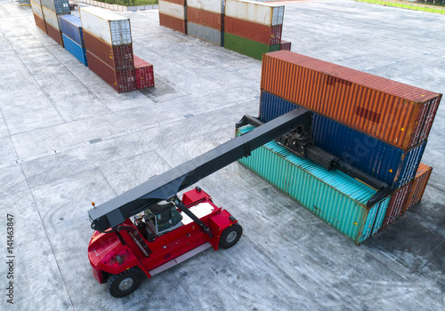Fotografie container stacker forklift working on lifting unit of container in yard in aeria