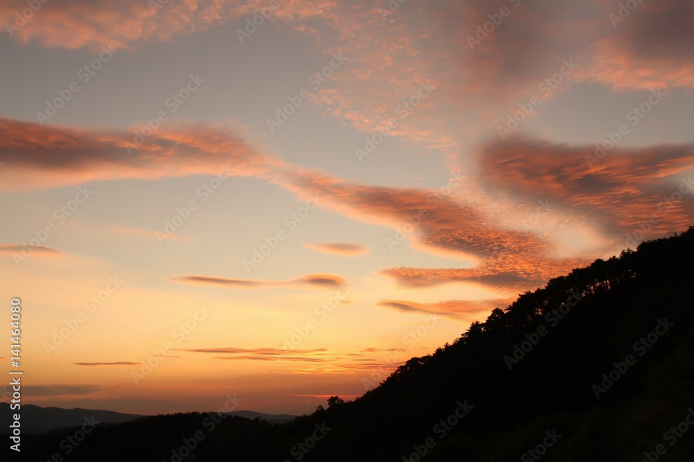 Amazing colourful sunset view in mountains with beautiful clouds