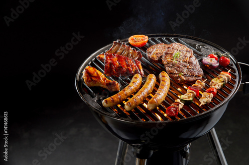 Assortment of marinated meat grilling on a BBQ