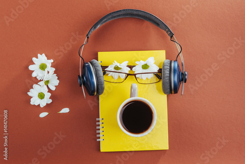 notebook, headphones and coffee on a brown wooden background photo