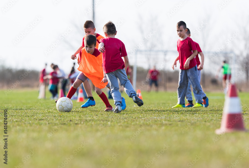 Obraz premium Kids soccer football - children players match on soccer field