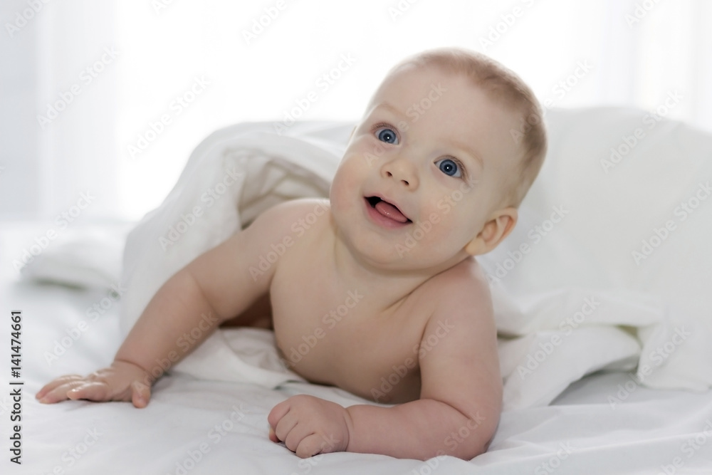 Cute little boy on the bed In front of the window