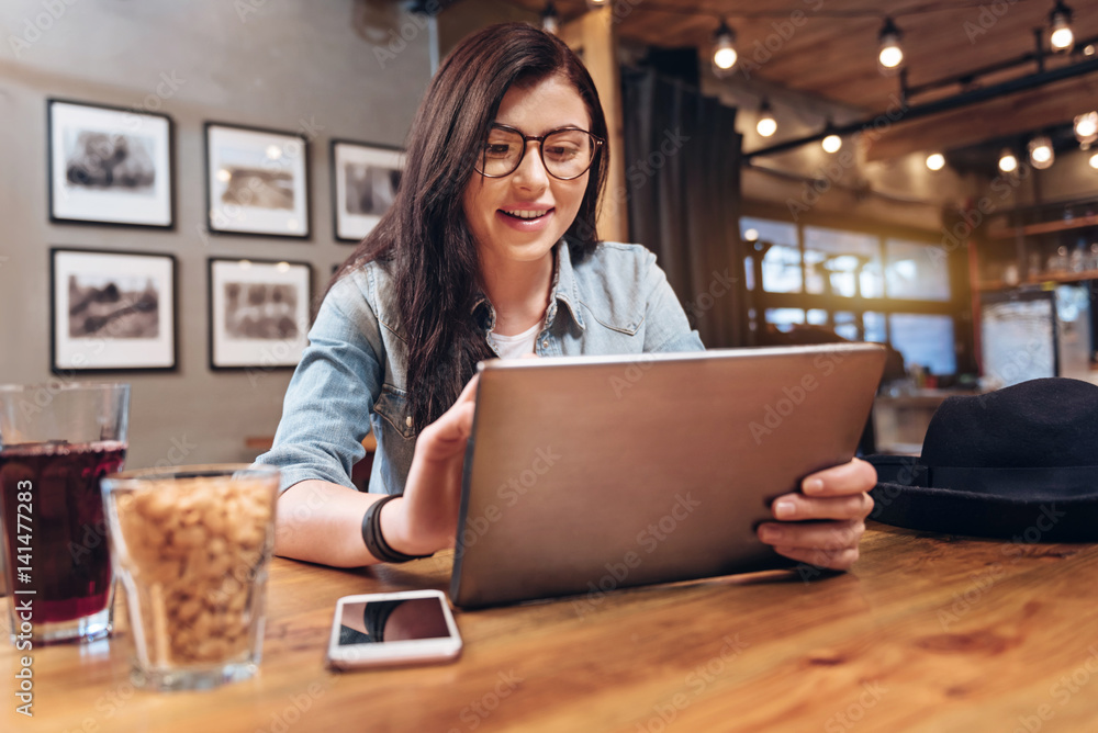 Smiling brunette using her device Smiling brunette using her device
