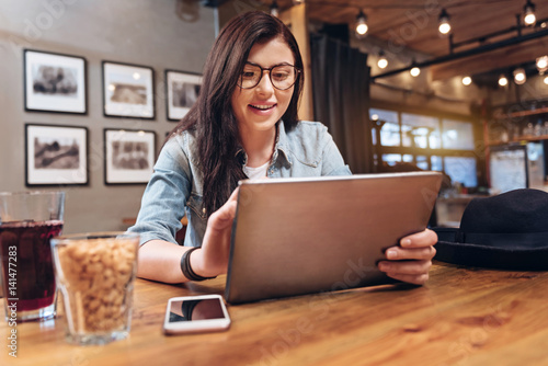 Smiling brunette using her device