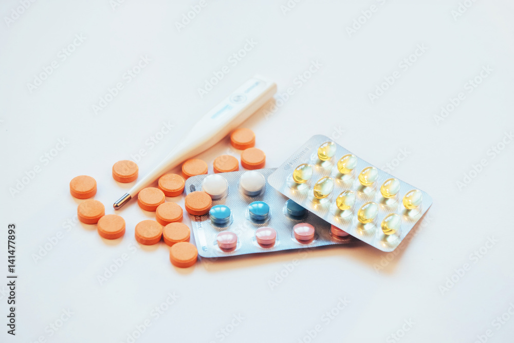 Flu. Thermometer with elevated temperature and many pills on light background Flu. Thermometer with elevated temperature and many pills on light background