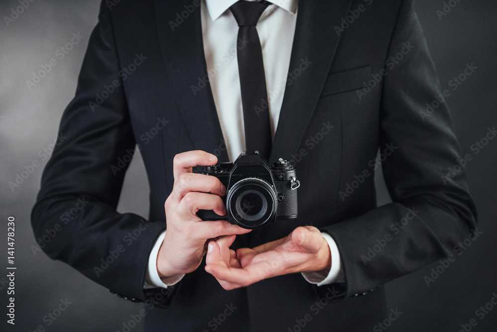 man holding black digital camera. In the studio man holding black digital camera. In the studio
