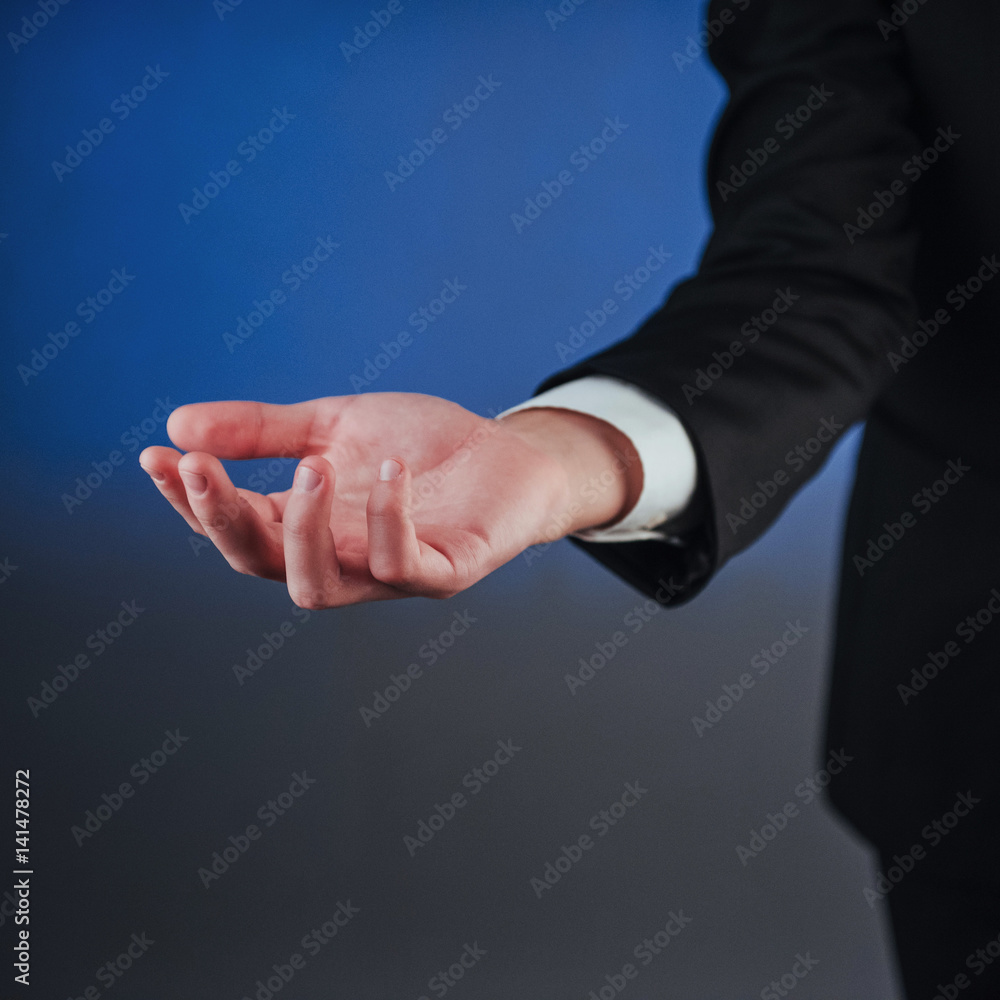 Fototapeta premium Young businessman showing empty hands, ready to fill with your design