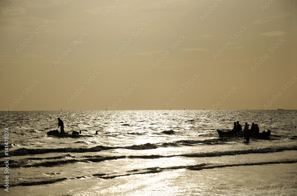 Silhouette Thai people and traveler travel and playing jetski and banana boat with wave on the sea at Bangsaen Beach