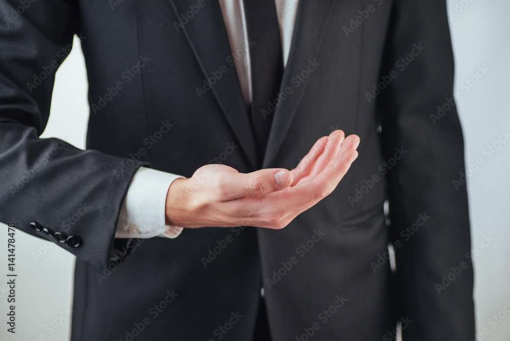 Young businessman showing empty hands, ready to fill with your design
